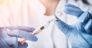 Close-up of a healthcare professional drawing medication into a syringe, illustrating preparation techniques during Injection Training in Houston, TX.