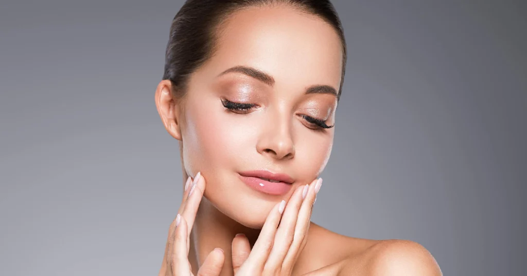 Woman showing glowing, smooth skin gently touching her face after Microneedling in Houston, TX, showcasing rejuvenated and youthful skin results.