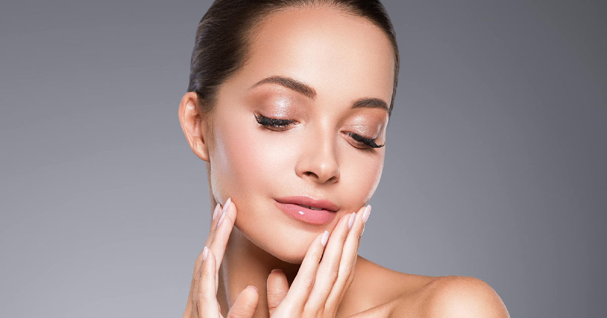 Woman showing glowing, smooth skin gently touching her face after Microneedling in Houston, TX, showcasing rejuvenated and youthful skin results.